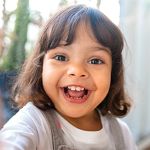 young girl smiling big