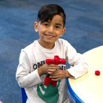 boy playing with toy at classroom table