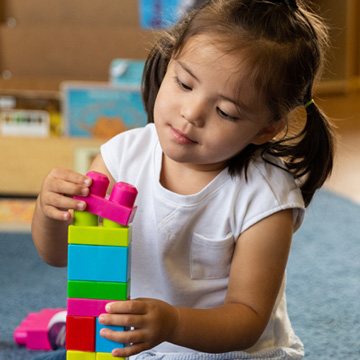 little girl stacking legos